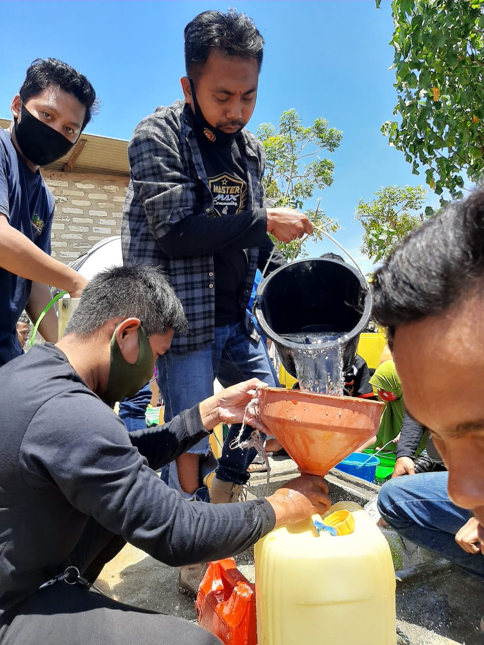 Khoirul Umam beserta rekan-rekan Master Maxnya sedang memberikan bantuan air bersih kepada warga terdampak kekeringan (Dok. Jatim Aktual)