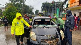 Petugas saat mengevakuasi mobil korban yang masuk ke gorong-gorong akibat banjir, menewaskan satu korban.