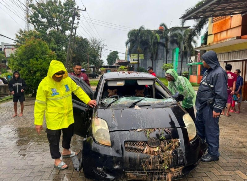 Petugas saat mengevakuasi mobil korban yang masuk ke gorong-gorong akibat banjir, menewaskan satu korban.