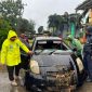Petugas saat mengevakuasi mobil korban yang masuk ke gorong-gorong akibat banjir, menewaskan satu korban.