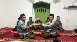 Kades Kota Raja Suwarni melakukan penyerahan surat suci Alqur'an saat melakukan Safari Ramadhan/ foto - Saipan Petir