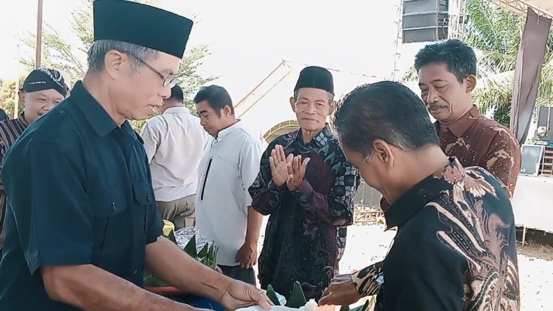 Camat Tabir Ilir didampingi Ketua BPD Air baru berikan tumpeng kepada tokoh masyarakat di hari jadi Desa air batu ke 40