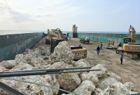 Proses pemindahan bongkahan batu kapur dari Dump Truk ke kapal muatan di Pelabuhan Pasean Pamekasan