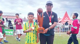 Kapten tim U 10, Rafa dan Pelatih SSB Laga Sota, Ach Zaini usai menerima penghargaan dalam turnamen Super Soccer Festival 2025 di stadion Jenggolo Sidoarjo, Minggu (6/7/2025).