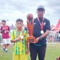 Kapten tim U 10, Rafa dan Pelatih SSB Laga Sota, Ach Zaini usai menerima penghargaan dalam turnamen Super Soccer Festival 2025 di stadion Jenggolo Sidoarjo, Minggu (6/7/2025).