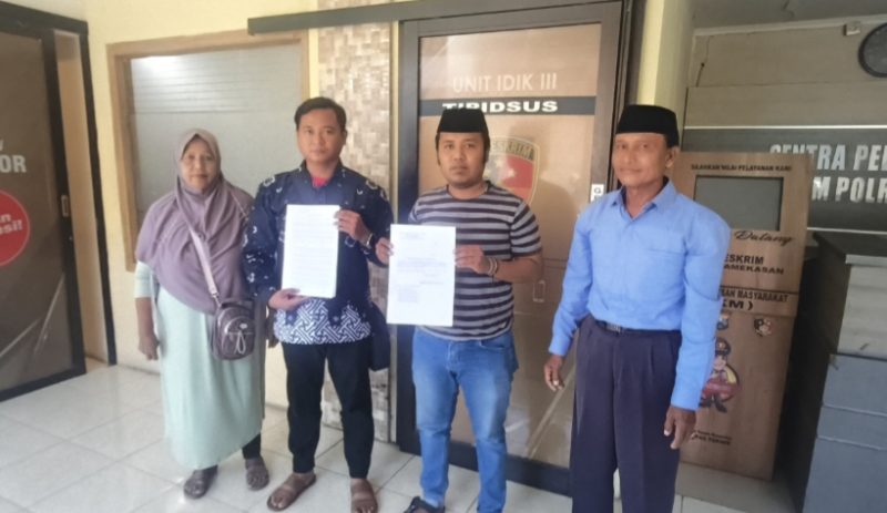 Budi Santoso dan Faridatul Hasanah saat menujukkan bukti laporan didampingi anaknya