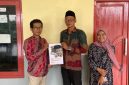 Sekretaris Desa Tanjung, Moh. Jerry, saat menerima draf regulasi Desa dari Ansori, S.H., M.H., Dosen Fakultas Hukum UTM. 