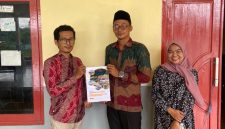 Sekretaris Desa Tanjung, Moh. Jerry, saat menerima draf regulasi Desa dari Ansori, S.H., M.H., Dosen Fakultas Hukum UTM.