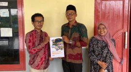 Sekretaris Desa Tanjung, Moh. Jerry, saat menerima draf regulasi Desa dari Ansori, S.H., M.H., Dosen Fakultas Hukum UTM. 