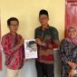 Sekretaris Desa Tanjung, Moh. Jerry, saat menerima draf regulasi Desa dari Ansori, S.H., M.H., Dosen Fakultas Hukum UTM. 