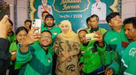 Gubernur Jawa Timur Khofifah Indar Parawansa berfoto bersama para pengemudi ojek online usai penyerahan bantuan di Gedung Negara Grahadi, Surabaya